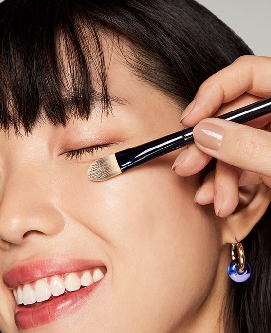 photo of woman applying concealer makeup pre event prep